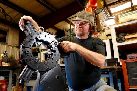 A Man In A Workshop Operating A Machine